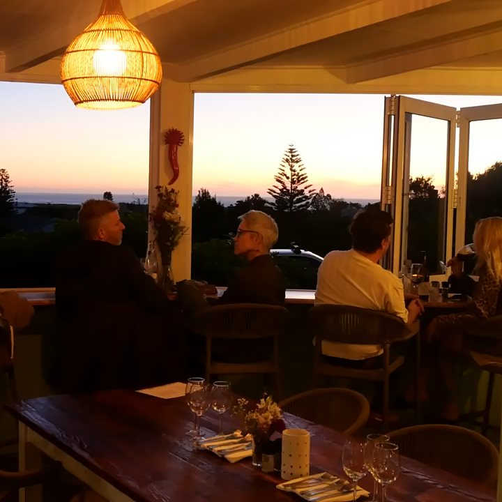 Guests at the window counter watching the sunset over the sea